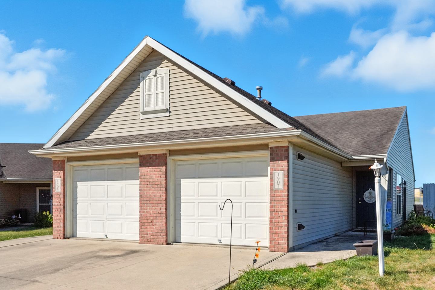 The duplex seen from its right end, with the second unit's entry door beside the garages.